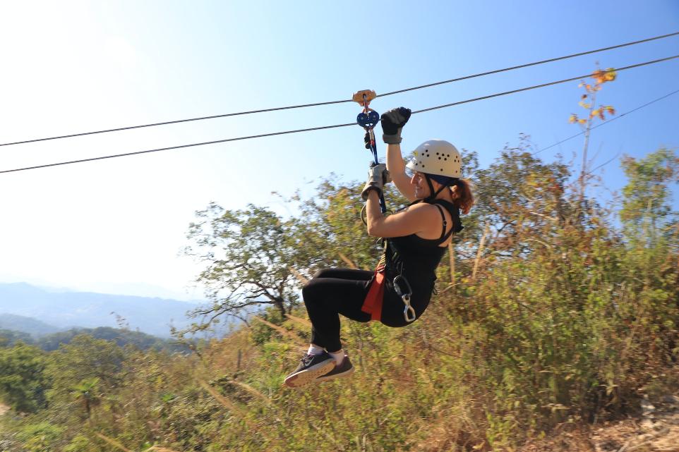 a woman is zipping through the air on a zip line